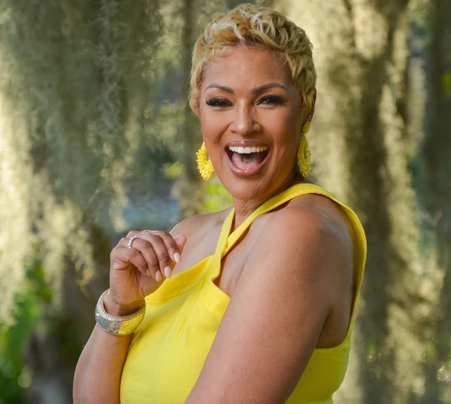 Tracey Young, founder of Rilassati, laughing outdoors in a yellow dress